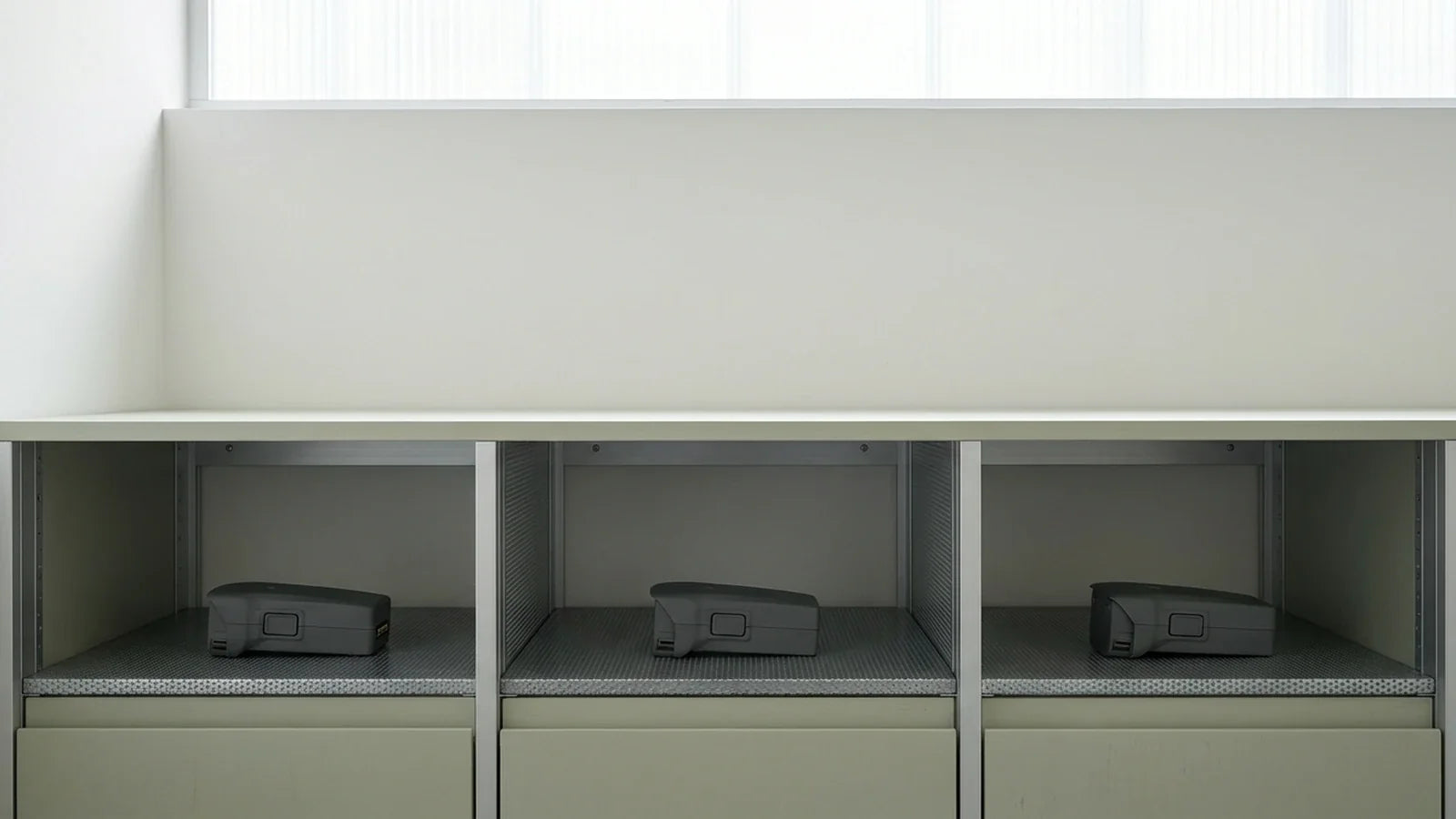 DJI Air 3 batteries resting separately in a dry ventilated equipment cabinet