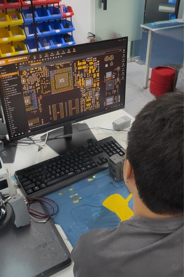 Reboot Hub technician reviewing a drone circuit board at a workstation