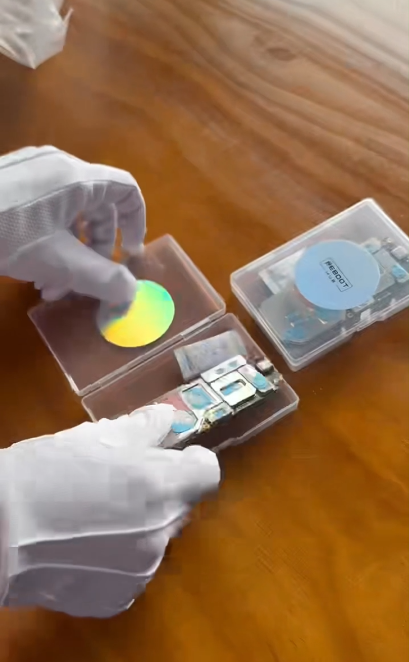 A Reboot Hub team member handles product parts with protective gloves.